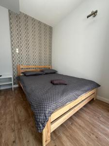a bedroom with a wooden bed in a room at Host-X Pokoje Ciche Centrum Mała Sienkiewicza -fv in Kielce