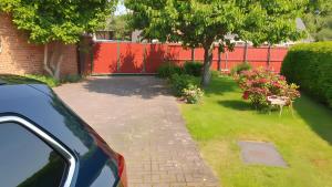 a garden with a red fence and a driveway at Ferienwohnung 1 in Bad Wilsnack