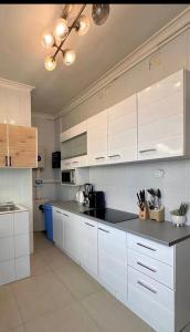 a kitchen with white cabinets and a black counter top at Charming apartment limete 1ere rue Kinshasa in Kinshasa