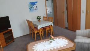 a living room with a table and chairs and a television at Ferienwohnung 1 in Bad Wilsnack +3 photos