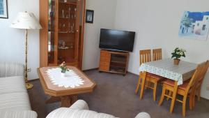 a living room with a table and a tv at Ferienwohnung 1 in Bad Wilsnack