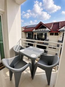 a patio with a table and chairs on a balcony at Charming apartment limete 1ere rue Kinshasa in Kinshasa