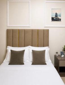 a bedroom with a large bed with white sheets and pillows at Charming apartment limete 1ere rue Kinshasa in Kinshasa