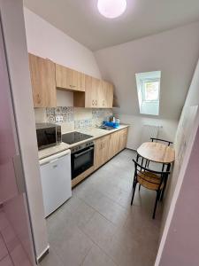 a kitchen with wooden cabinets and a table in it at Kékkúti Apartman in Kékkút