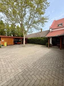 a tree sits in the middle of a brick driveway at Kékkúti Apartman in Kékkút