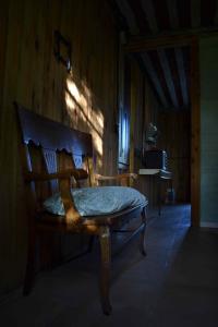1 dormitorio con silla de madera en una habitación en El Granero en Sierra de los Padres