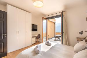 a bedroom with a bed and a desk and a television at Lake Como View 3BR Regina 35 in Carate Urio