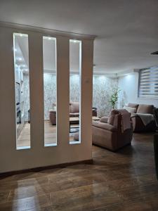 a living room with a couch and a large mirror at Museum Apartment in Subotica