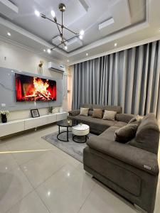 a living room with a couch and a tv at Charming apartment limete 1ere rue Kinshasa in Kinshasa