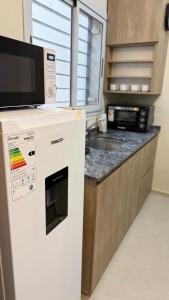 a kitchen with a white refrigerator and a microwave at Apart Zona Paula in San Juan
