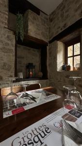a table with wine glasses and a newspaper on it at Le Rhum Antik in Puybrun
