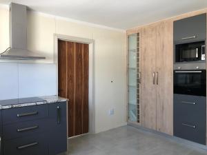 a kitchen with blue cabinets and a glass door at F2 Homestead in Omuthiya +6 photos