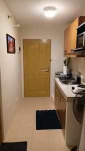 a small kitchen with a yellow door and a sink at Relaxing Urban Retreat - Marina Spatial in Piapi