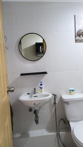 a bathroom with a sink and a mirror and a toilet at Relaxing Urban Retreat - Marina Spatial in Piapi +13 photos
