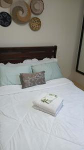 a white bed with two folded towels on it at Relaxing Urban Retreat - Marina Spatial in Piapi