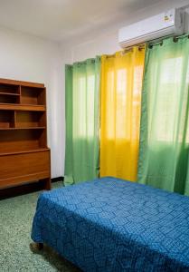 a bedroom with green and yellow curtains and a bed at La Milagrosa in Caracas
