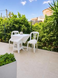 a white table and two chairs on a patio at Studio Malades, Heraklion in Maládhes +3 photos