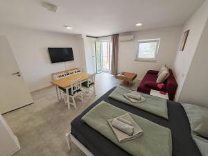 a room with two beds and a table and a couch at Apartments Pronavtik in Piran