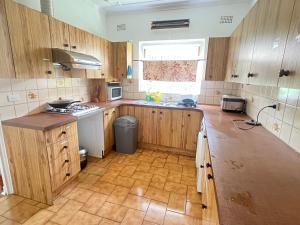 a large kitchen with wooden cabinets and a window at Room 53 in Sydney