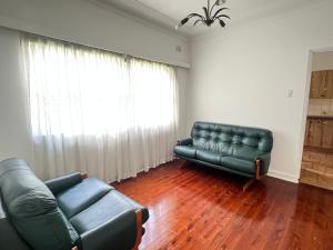 a living room with a couch and a couch and a chair at Room 53 in Sydney