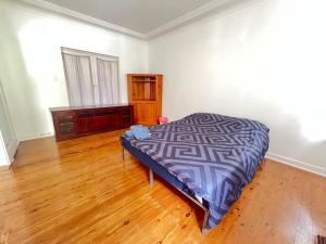 a bedroom with a bed and a wooden floor at Room 53 in Sydney