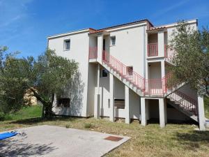 a large white building with a red balcony at Adria in Pašman