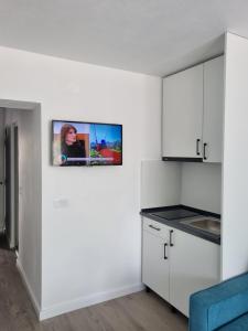a kitchen with a tv hanging on the wall at Unilux Residence in Beiuş