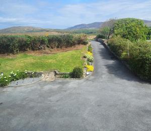 an empty road with flowers on the side at Ben Breen House Apartment in Crockaunroe