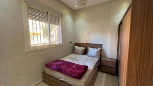 a small bedroom with a bed with a window at Exclusive Modern Garden Flat ,Marrakech in Marrakesh