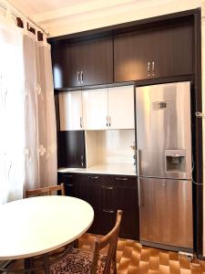 a kitchen with a white table and a refrigerator at Nice Apartment in the City Center in Yerevan