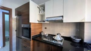 a kitchen with white cabinets and a stove top oven at Exclusive Modern Garden Flat ,Marrakech in Marrakesh