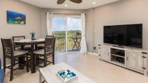 a living room with a television and a table with chairs at 2402 Ocean Pointe in Tavernier