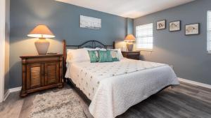 a bedroom with a bed and a lamp on a night stand at 2402 Ocean Pointe in Tavernier +37 photos