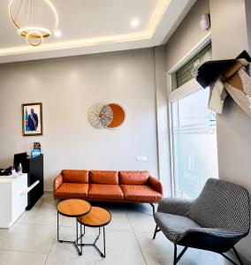a living room with a couch and two chairs at Ixoras Hotel Lemba in Kinshasa