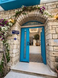 an entrance to a house with a blue door at Mavi Konak Alaçatı in Alaçatı