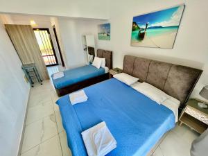 ein Hotelzimmer mit zwei Betten und einer Couch in der Unterkunft Studios Litsa in Pefkari