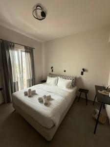a bedroom with a large white bed with towels on it at Mellow Paros in Parikia