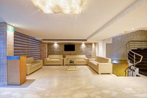 a large living room with couches and a television at Hotel Mayur in New Delhi