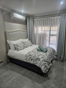 a bed sitting in a room with a window at Nolangeni Lodge in Margate +82 photos