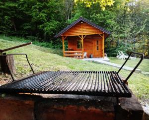 a wooden cabin with a bench in front of it at Brvnara in Arandelovac