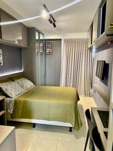 a small bedroom with a bed and a television at Ap standard confort bem localizado in Campina Grande