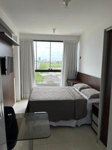 a bedroom with a bed and a large window at Ap standard confort bem localizado in Campina Grande