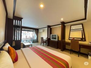 a hotel room with a bed and a television at Puektian Seaview in Ban Tanot Noi