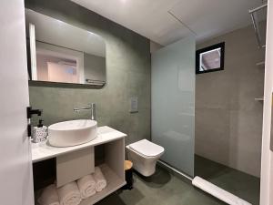a bathroom with a sink and a toilet at Avra Rooms in Limnionas