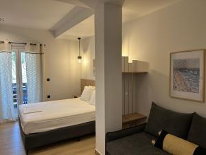 a bedroom with a bed and a couch in a room at Avra Rooms in Limnionas