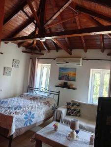 a bedroom with a bed and a couch and a table at Villa Fraoulitsa in Skoutari