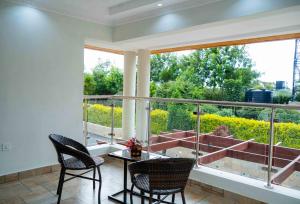 a room with a table and chairs and a large window at Lusoi Gardens Naromoru in Nyeri
