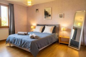 a bedroom with a bed with two towels on it at Maison Céline - Jardin clos et Parking Privé Gratuit in Crevant-Laveine