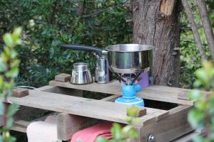 a bird feeder on a wooden table with a bucket at La caravane plage in Pietroso