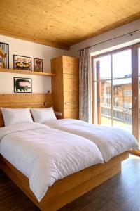 a bedroom with two beds and a large window at Chalet Cosy in Bramberg am Wildkogel +6 photos